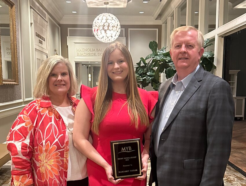 Maggie Taylor, center, with parents Mark and Amy Taylor, shows off her 2024 Merit Scholarship from the Mississippi Young Bankers.